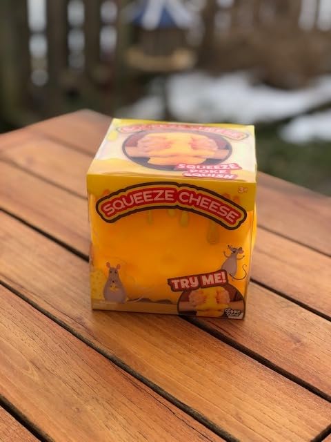 Sunny Days Squeeze Cheese box on a wooden picnic table in a snowy backyard, with a TRY ME window on the front